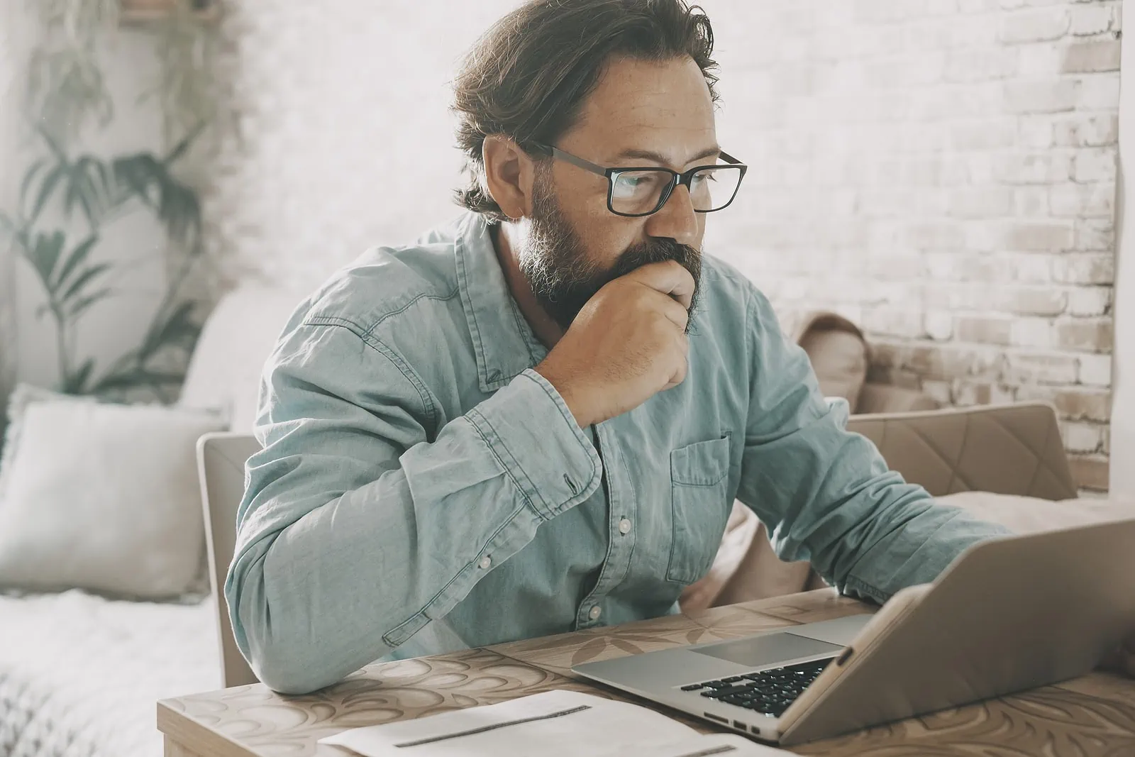 Stressed man working on laptop at home on the table