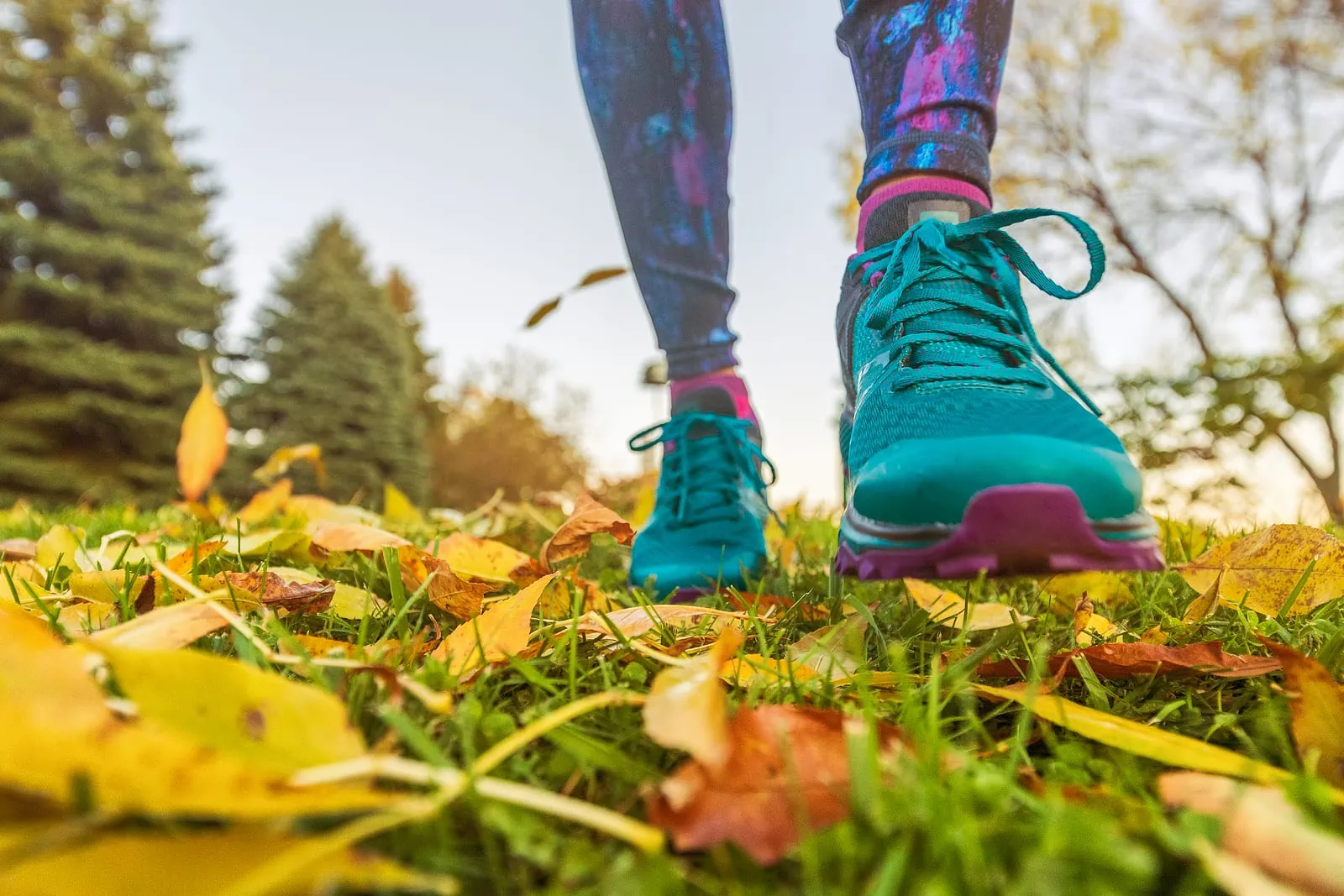 Walking outdoor in autumn nature park with running shoes in yellow fall leaves