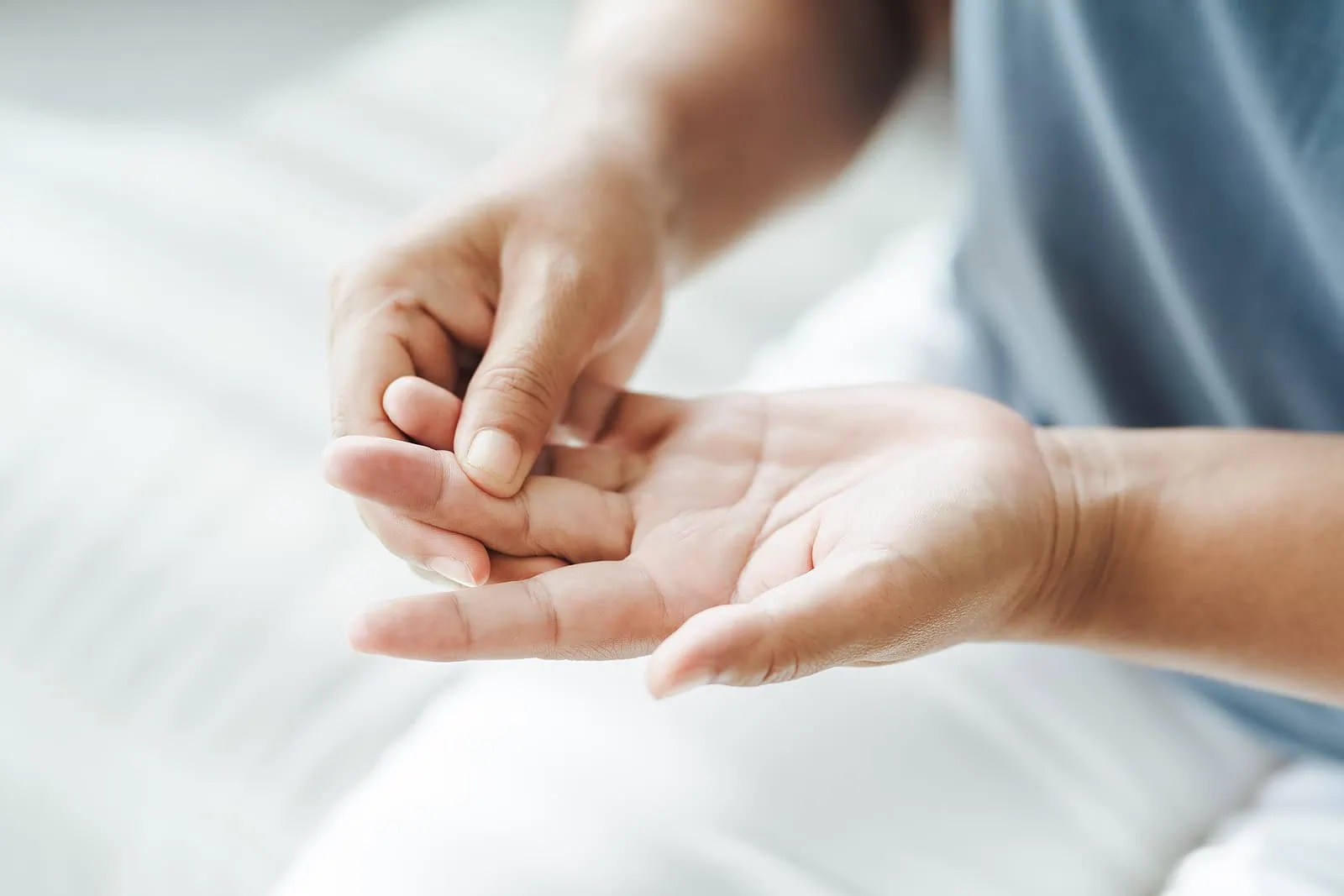Person checking their finger joints for arthritis symptoms.